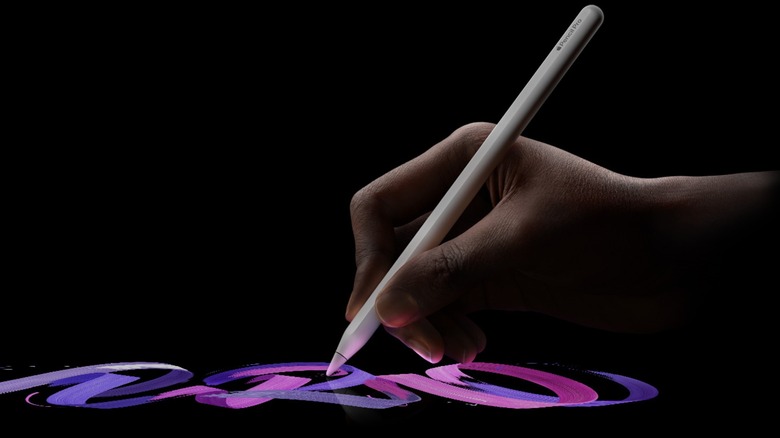 A hand holding an Apple Pencil