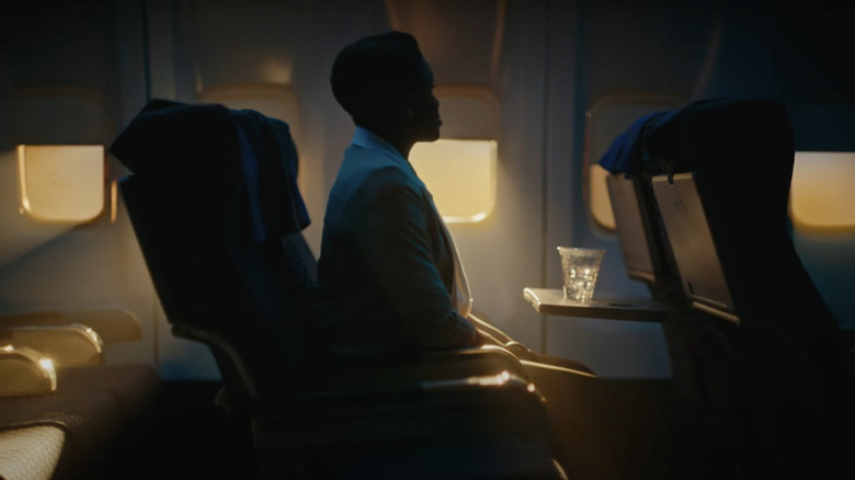 Air marshal sitting on plane with ice water on tray table