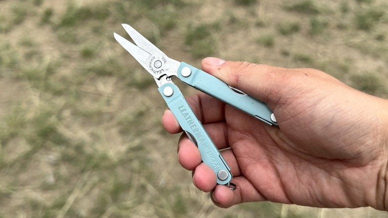 Holding a blue Micra Leatherman multi-tool