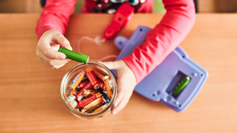 Child removing batteries from toy