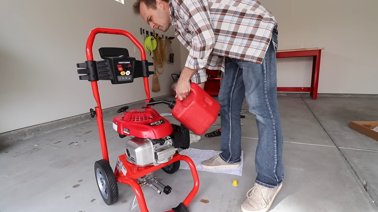 Man puts fuel inside a gas-powered pressure washer