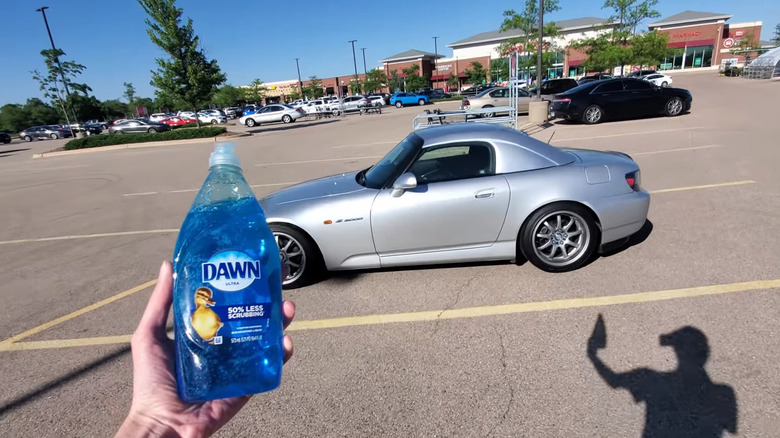 Hand holding a Dawn dish soap in front of a Honda S2000