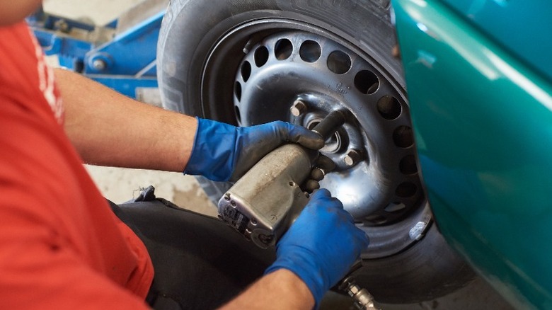 person removing tire with impact driver