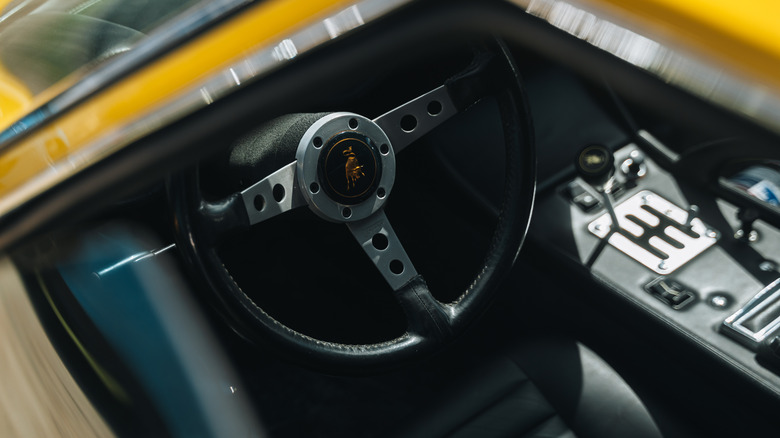 Looking through the window at the steering wheel and gated shifter on the Miura.