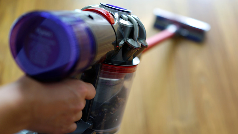 Person using Dyson cordless vacuum