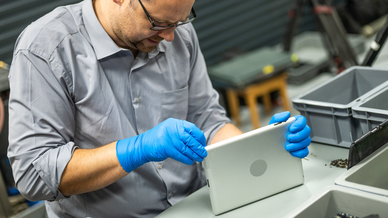 Man repairing iPad-shaped tablet