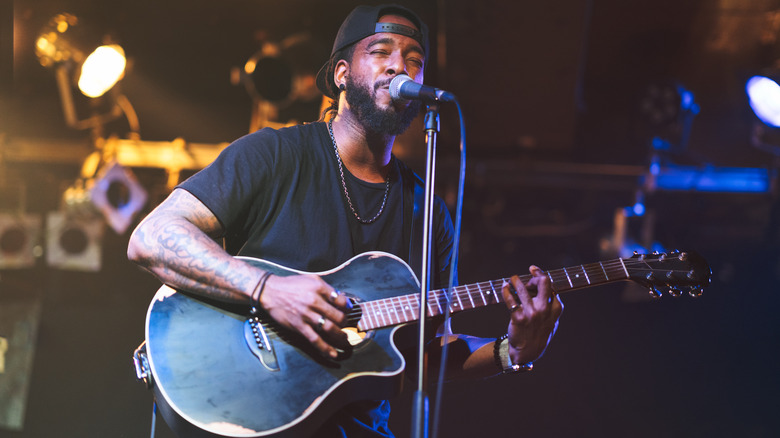 Guitarist singing on stage into mic 