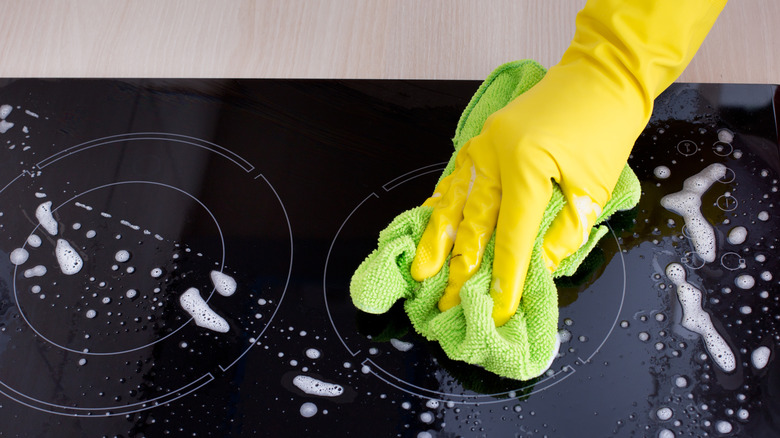 person cleaning induction hob