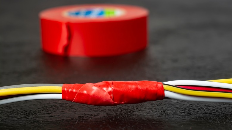 A wired connection insulated with red electric tape.