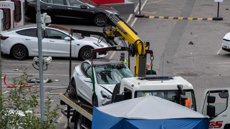 Tesla car is loaded onto a truck at a Tesla garage after an incident at Park Royal tube station