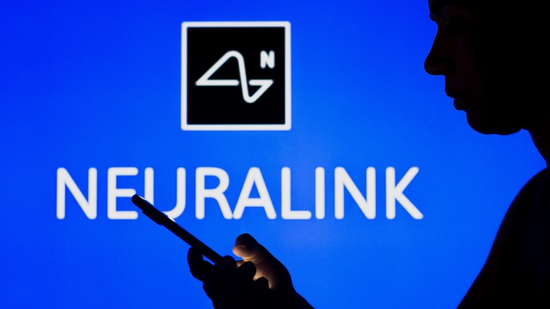 neuralink logo behind phone