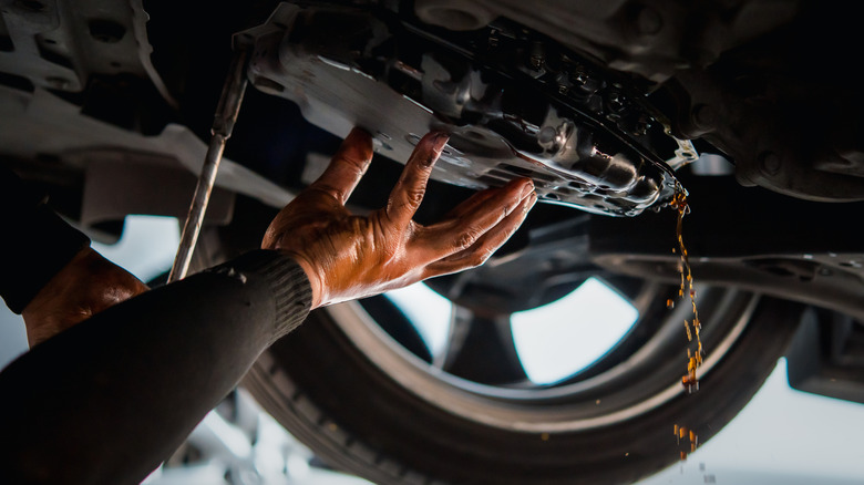 Mechanic working on vehicle underside