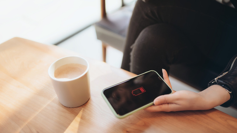 woman holding on to smart phone that needs charging