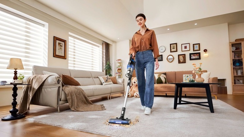 Woman using Eureka Stylus Elite vacuum