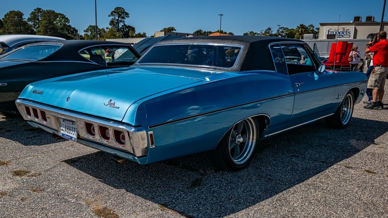 A blue Chevy Impala parked in a parking lot