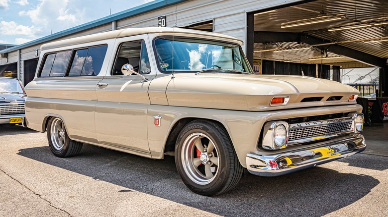 A 1964 Chevy Suburban parked by a garage