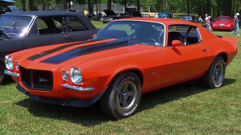 An orange and black 1971 Camaro Z/28 parked at a car show