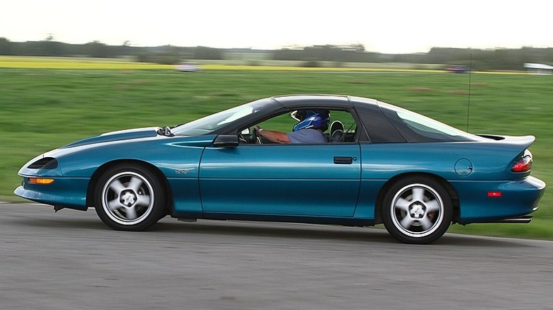 A green fourth generation Camaro driving on track