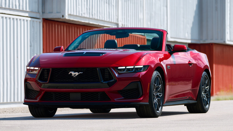 Red 2024 Ford Mustang convertible parked with hood down