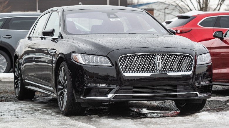 Black Lincoln Continental sedan parked in s snowy dealership lot