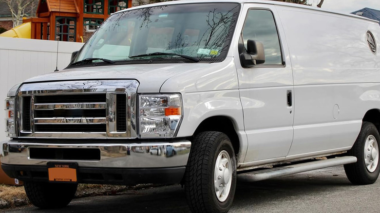 A white Ford E250 parked on a city street