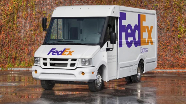 A FedEx box van in a wet parking lot