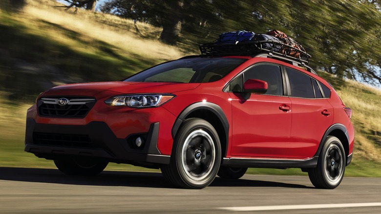 Red 2023 Subaru Crosstrek driving on asphalt