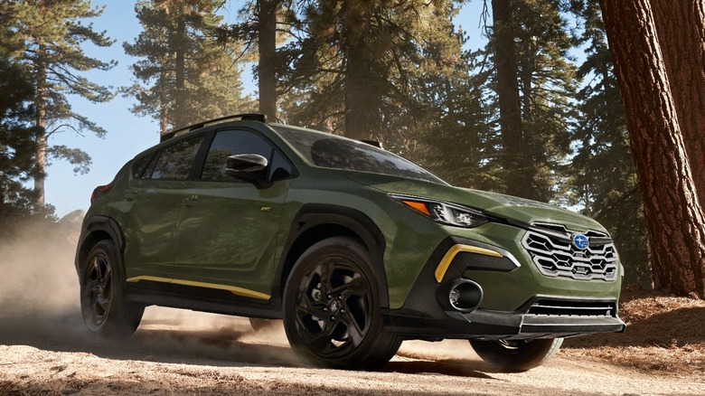 Green 2024 Subaru Crosstrek driving on dirt