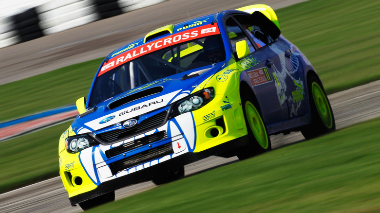 A blue and yellow Subaru WRX rally car