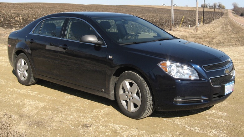 Black Chevrolet Malibu parked on dirt