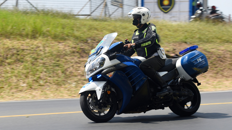 A Kawasaki Concourse driven by police down a road.