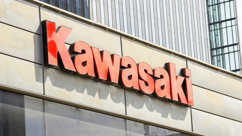 A red Kawasaki logo on the outside of a building