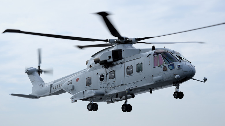 A gray Kawasaki MCH-101 helicopter in flight