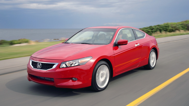 The Honda Accord Coupe V6 in red driving, front 3/4 view