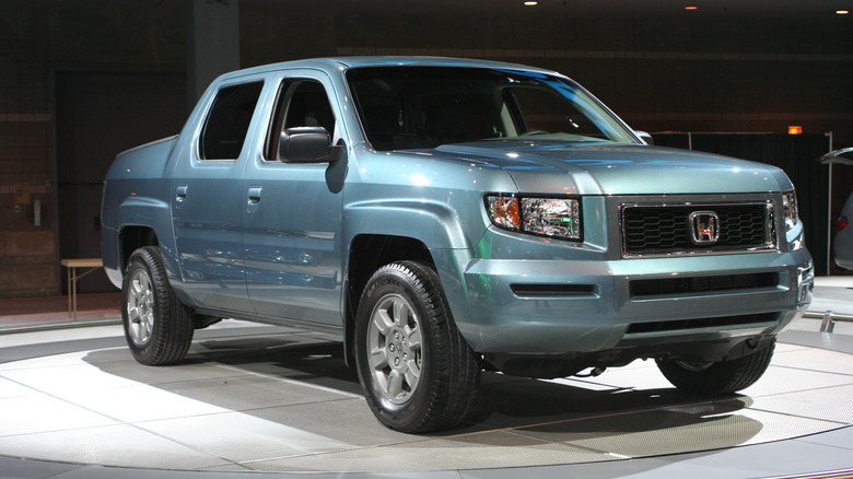 The original Honda Ridgeline on an auto show floor in light blue, front 3/4 view