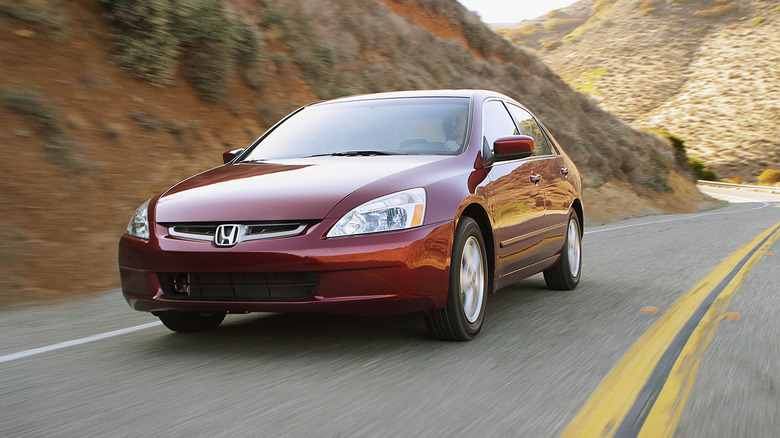 Red 2003 Honda Accord sedan driving on a twisty road