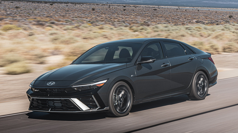 The Hyundai Elantra N in dark gray driving, front 3/4 view