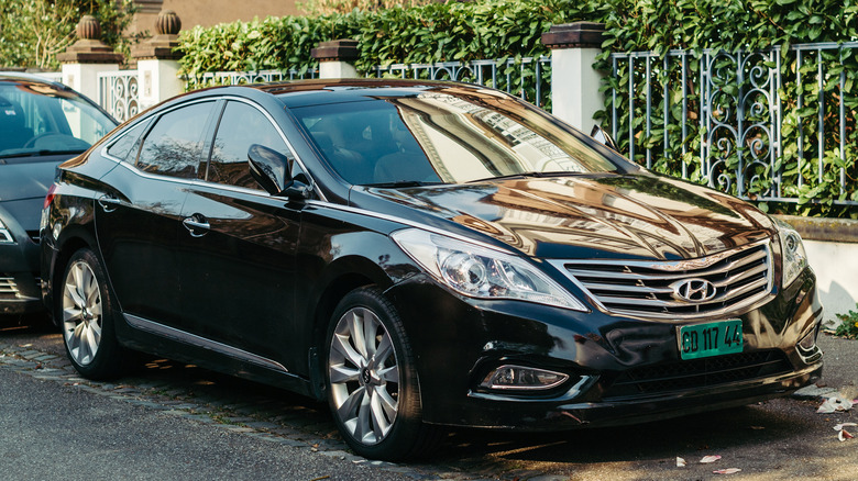 A street parked Hyundai Azera in black, front 3/4 view