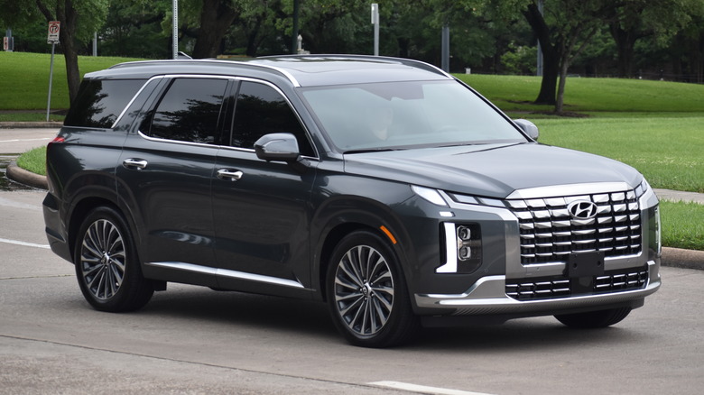 A facelift Hyundai Palisade in dark gray on the move, front 3/4 view