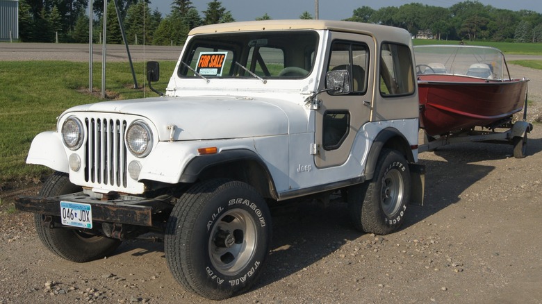 White CJ-7 parked on gravel with trailer attached