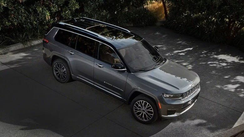 Jeep Grand Cherokee L parked on a pavement with trees in the background