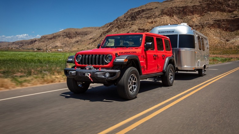 Red 2025 Jeep Wrangler Rubicon towing an Airstream travel trailer