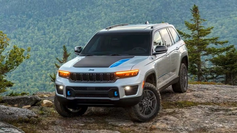 2025 Jeep Grand Cherokee 4xe Hybrid parked on mountain top in front of a forest