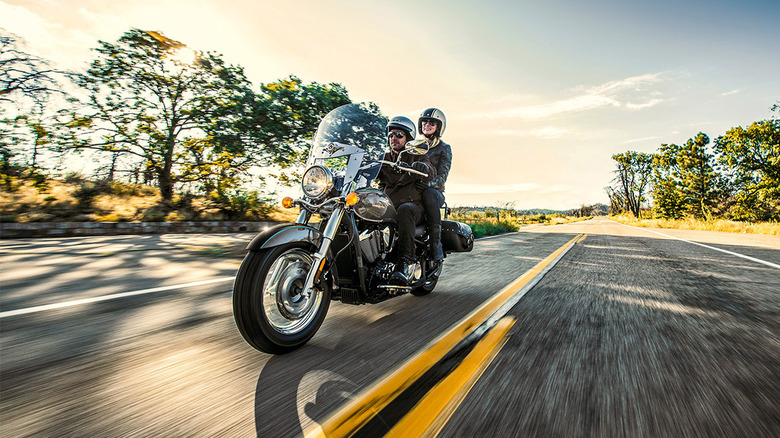 A person riding a Vulcan 900 Classic with a passenger