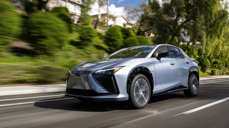 2024 Lexus RZ EV driving at speed in urban environment front 3/4 view