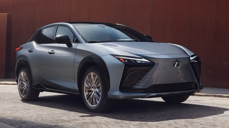 Ether Lexus RZ 300e driving next to a brown wall