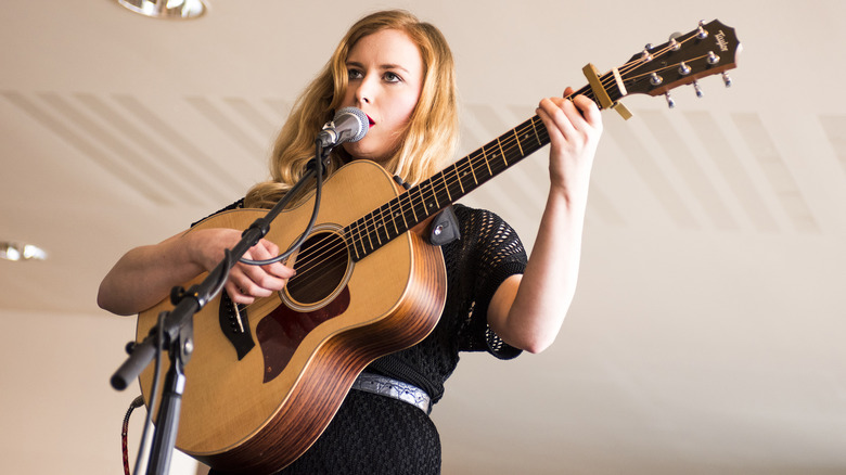 woman playing a Taylor guitar