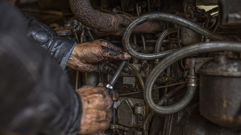 A mechanic working on an old engine