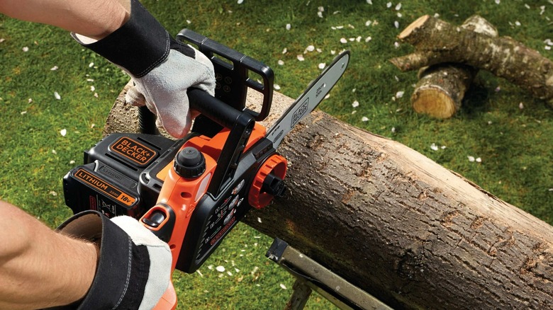 cutting log with a Black + Decker chainsaw