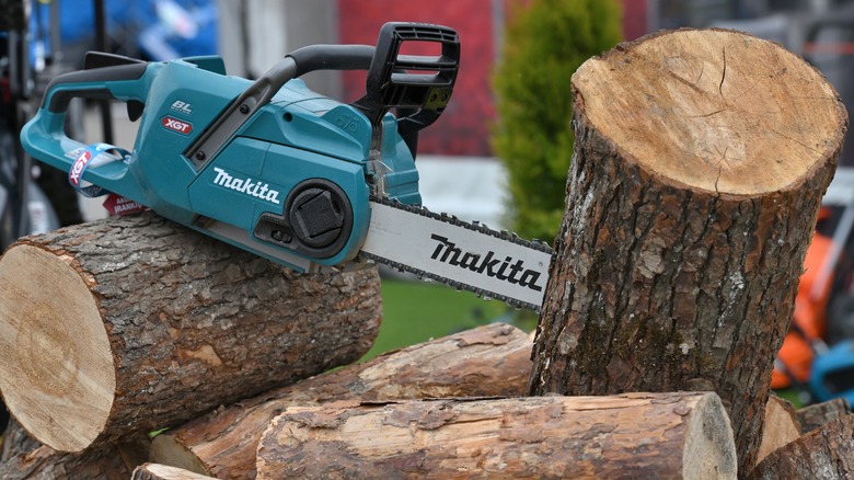 a Makita chainsaw in a log